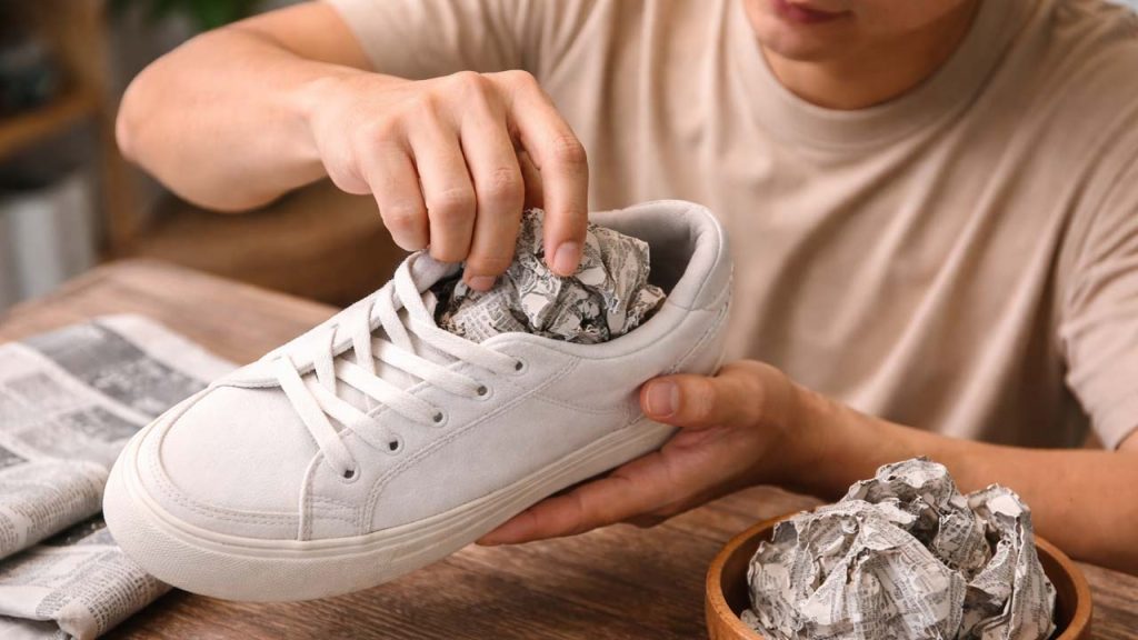 Nhét giấy báo vào giày để hút ẩm và khử mùi hôi hiệu quả