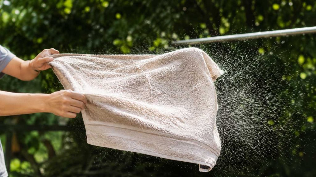 Giũ mạnh khăn trước khi phơi giúp khăn mềm hơn sau khi khô