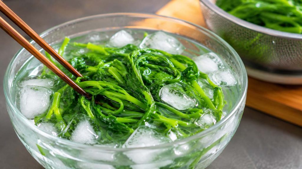 Rau muống luộc được ngâm trong tô nước đá để giữ màu xanh giòn