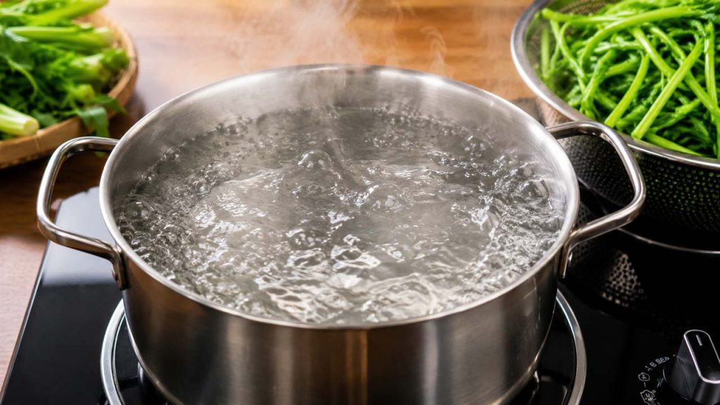 Nồi nước đang sôi mạnh để luộc rau muống xanh giòn ngon