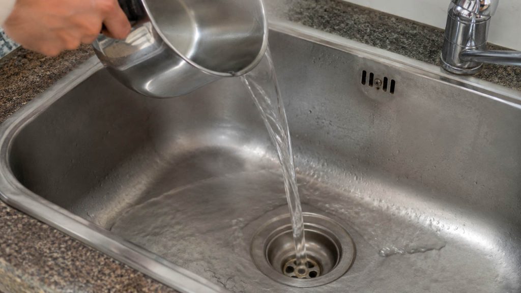 Đổ nước nóng xuống cống để giảm mùi hôi và làm sạch đường ống