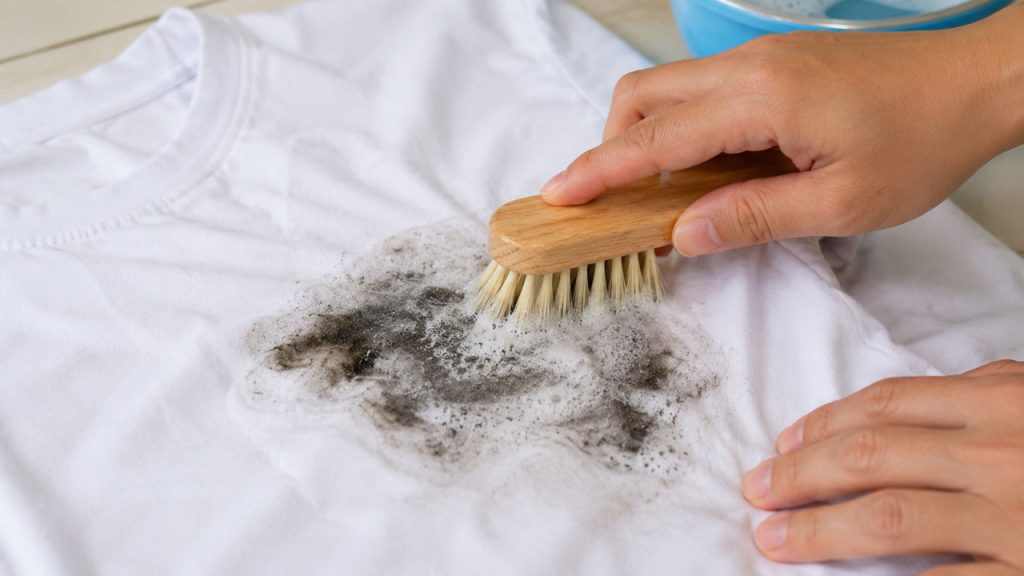 Dùng bàn chải mềm chà nhẹ vết dầu nhớt trên áo