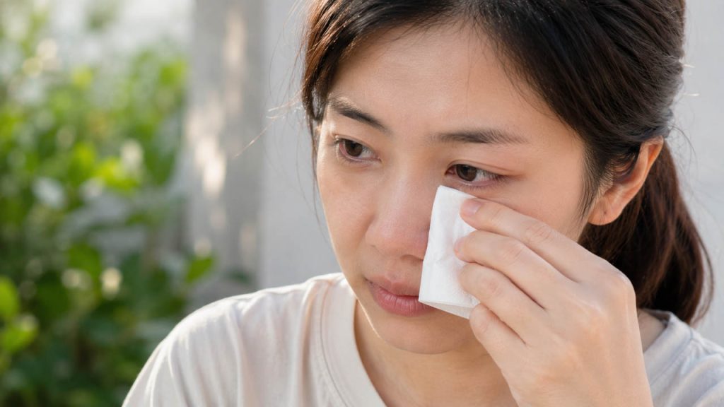 Dùng khăn giấy sạch thấm nước mắt ở khóe mắt sau khi bụi được đẩy ra ngoài