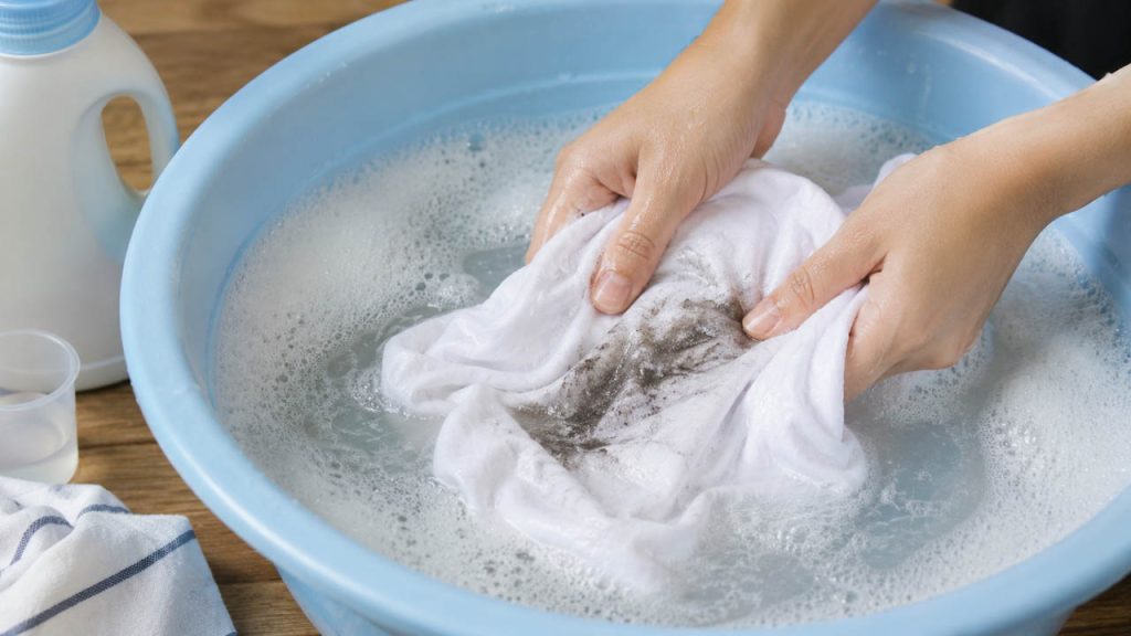 Ngâm áo bị dính dầu nhớt với nước giặt trước khi giặt