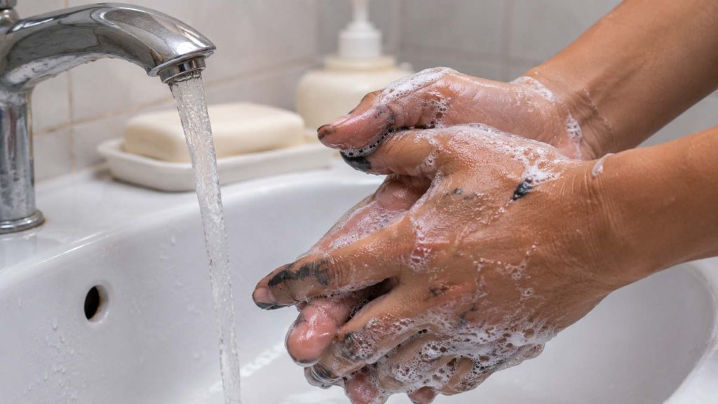 Rửa ngay bằng nước ấm và xà phòng để làm sạch sơn trên tay