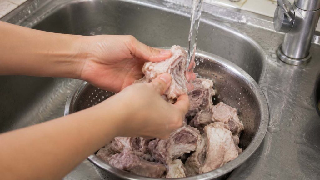 Rửa sạch xương sau khi chần để nước dùng không bị đục