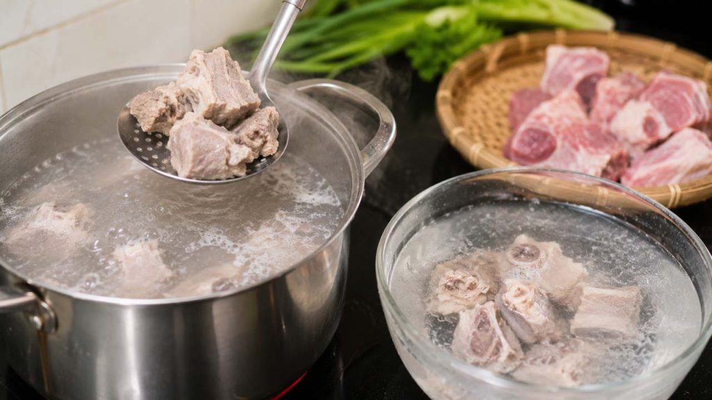 Chần thịt và xương trong nước sôi để loại bỏ cặn làm đục nước canh