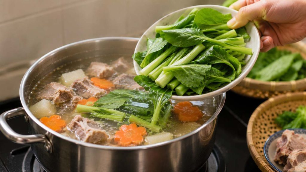 Cho rau xanh vào nồi canh khi các nguyên liệu khác gần chín