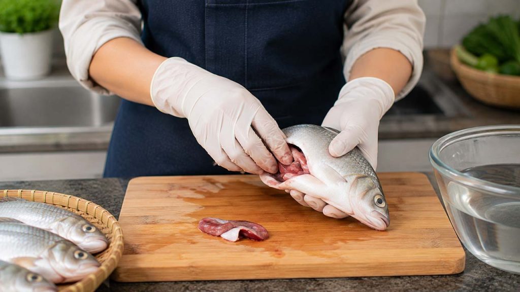 Đeo găng tay khi sơ chế cá để hạn chế mùi tanh bám tay