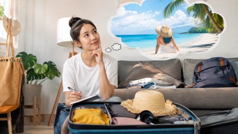 Mẹo chuẩn bị nhà cửa trước khi đi du lịch: Một người đang chuẩn bị nhà cửa trước khi đi du lịch dài ngày, vừa sắp xếp hành lý vừa lên kế hoạch cho chuyến đi.